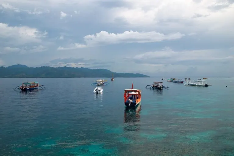 Boats on the Lombok Strait with clouds above the Gili Islands